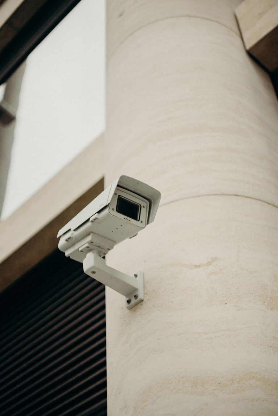 A security camera mounted on a wall above a roller door