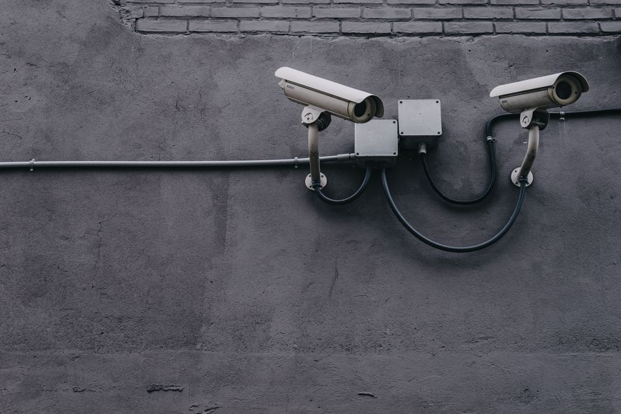 A surveillance camera mounted on a brick wall